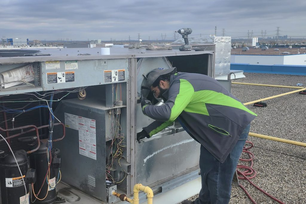 Technician inspecting a rooftop HVAC system as part of professional duct cleaning services in Kleinburg.