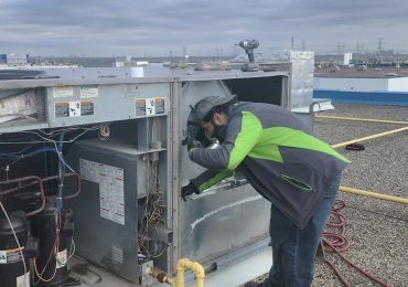 Technician inspecting a rooftop HVAC system as part of professional duct cleaning services in Kleinburg.